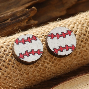 Macro view of handmade wooden baseball earrings on natural wood and linen background