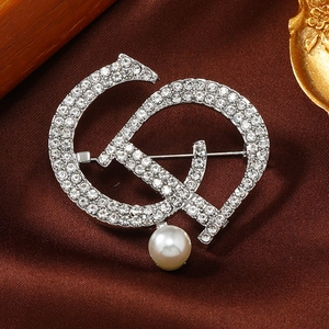 Macro shot of sparkling rhinestone hammer and sickle brooch with a round white pearl detail
