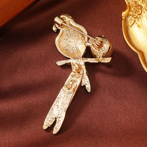 Detailed back view of parrot brooch featuring golden textured alloy and safety pin closure