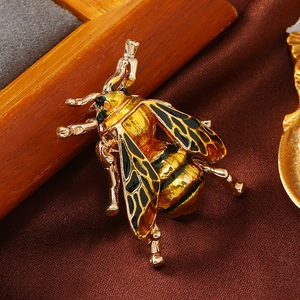 Macro shot of detailed honeybee brooch with gold metal and vibrant enamel wings