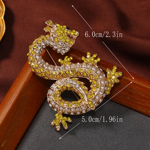 Detailed view of the 6.0cm by 5.0cm gold dragon brooch with crystal encrusted dragon scales