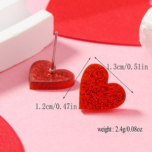 Macro view of red glitter heart stud earrings showing 1.3cm size and texture