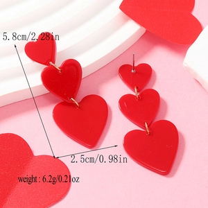 Detailed view of red acrylic triple heart drop earrings with size and weight measurements