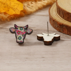 Primer plano de los pendientes de cabeza de vaca con estampado floral y madera fina