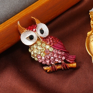 Macro detail of owl brooch with colorful rhinestones on vintage golden base