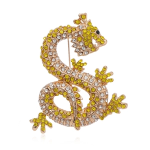Luxurious gold-tone dragon brooch with yellow and white crystal inlays on white background