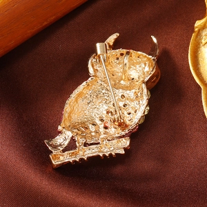 Detailed macro shot of the golden owl brooch back featuring a secure metal pin clasp