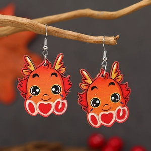 Detail of wooden cartoon dragon drop earrings with heart motif and love text on branch