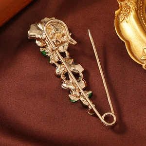 Detail view of vintage brooch back with large safety pin clasp and green enamel finish