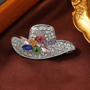 Detail of a sparkling silver sun hat brooch with colorful rhinestones on brown silk
