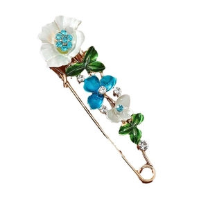 Elegant gold floral brooch with blue and white enamel petals and sparkling rhinestones