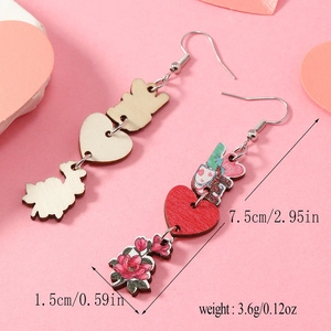 Détail de boucles d'oreilles asymétriques en bois avec motif LOVE et imprimé floral