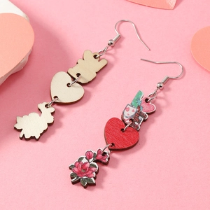 Détail de boucles d'oreilles en bois découpées au laser avec lettres LOVE et motif fleur