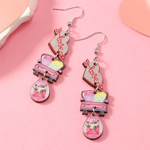 Détail de boucles d'oreilles en bois avec voiture rose et cœurs sur fond de pierre
