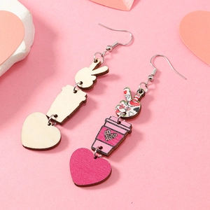Détail de boucles d'oreilles asymétriques en bois avec breloques cœur et café en rose et bois