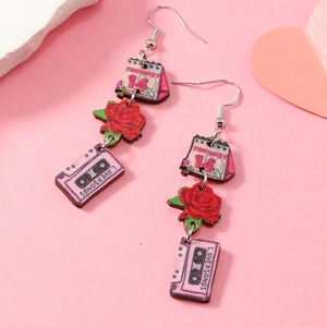 Détail de boucles d'oreilles en bois rose avec calendrier du 14 février et roses