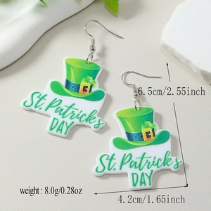 Détail macro de boucles d'oreilles en acrylique St. Patrick avec chapeau vert sur pierre