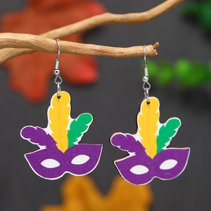 Vue détaillée de boucles d'oreilles masque de Mardi Gras avec plumes sur une branche
