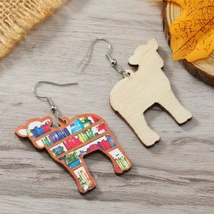 Dettaglio di orecchini in legno a forma di lama con motivo libreria e venature naturali