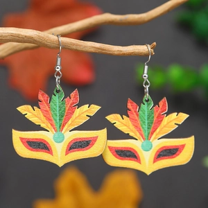 Gros plan de boucles d'oreilles masque de carnaval en bois avec plumes colorées