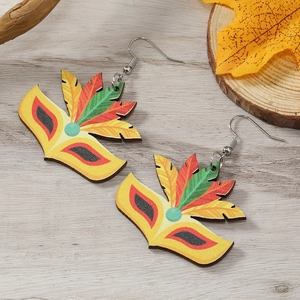 Détail macro de boucles d'oreilles masque de carnaval avec motifs plumes colorées sur bois