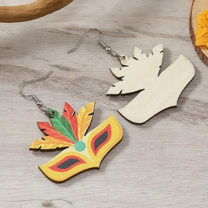 Détail macro de boucles d'oreilles en bois pour carnaval avec masques et plumes