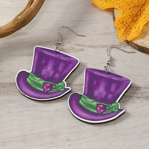 Détail de boucles d'oreilles chapeau violet avec ruban vert sur fond bois rustique