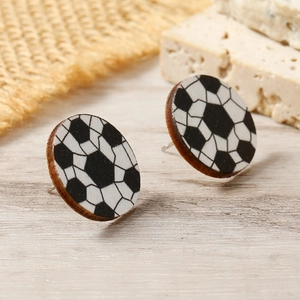 Detail view of round wooden soccer ball stud earrings with natural wood grain texture
