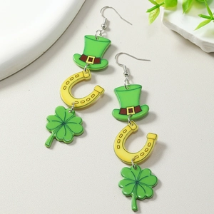 Gros plan de boucles d'oreilles St Patrick avec chapeau vert, fer à cheval et trèfle