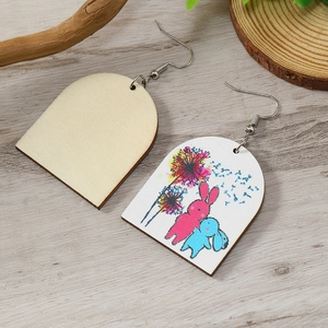 Detailoverzicht van handgemaakte houten oorbellen met schattige paashaas-illustraties