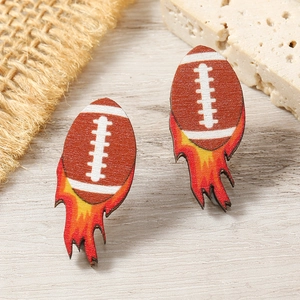 Macro detail of wooden rugby earrings with flame patterns on natural wooden surface