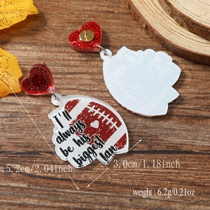 Macro detail of rugby acrylic earrings with heart studs and weight measurements