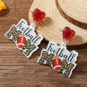Detailed close-up of acrylic Football MOM earrings with leopard print and red glitter heart