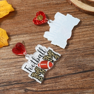 Detail of acrylic football heart earrings with leopard print and Football MOM text