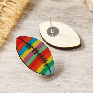 Close-up of rainbow striped wooden rugby earrings with metal posts on rustic background