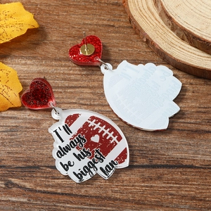 Detail of football acrylic earring with red glitter heart and fan letter print