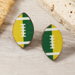 Detail shot of yellow and green wooden rugby football stud earrings on a textured background