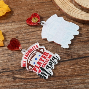 Macro shot of acrylic rugby heart earrings with Mama print on a rustic wood surface