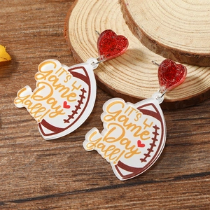 Detail of football shaped acrylic earrings with IT'S Game Day y'all text and red heart