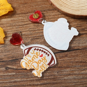 Macro view showing both sides of acrylic football earrings with It's Game Day text