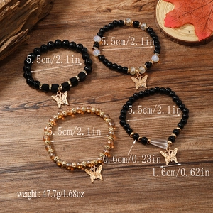Detailansicht eines 4-teiligen Perlenarmband-Sets mit goldenen Schmetterlingsanhängern