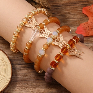 Detail eines böhmischen mehrlagigen Perlenarmbands mit goldenen Schmetterlingsanhängern