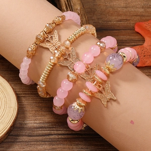 Nahaufnahme der böhmischen Perlenarmbänder mit rosa Perlen und Schmetterlingsanhänger