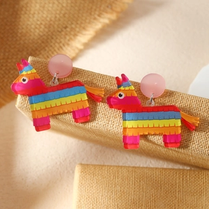Kleurrijke Mexicaanse Piñata acryl oorbellen op een rustieke standaard voor feesten