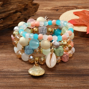 Details von böhmischen mehrlagigen Perlenarmbändern mit Muscheln auf rustikalem Holz