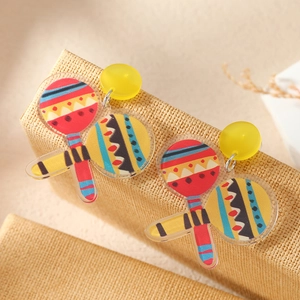 Detailed close-up of acrylic maracas earrings on a textured jewelry display stand