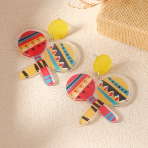 Macro detail of acrylic maraca earrings with vibrant ethnic geometric patterns