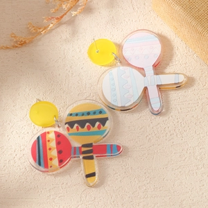 Macro shot of colorful acrylic maraca drop earrings with vibrant tropical festive details