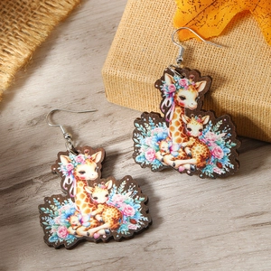 Detailed close-up of wooden giraffe mother and baby earrings with floral printed patterns