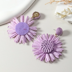 Macro detail of handmade lavender raffia sunflower earrings with metal studs and felt backing